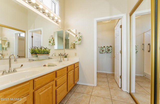 bathroom with tile patterned flooring, a sink, baseboards, and double vanity