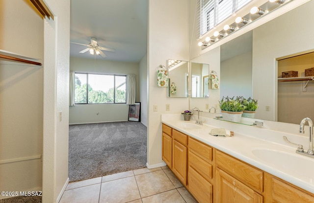 bathroom featuring a ceiling fan, tile patterned flooring, a sink, and double vanity