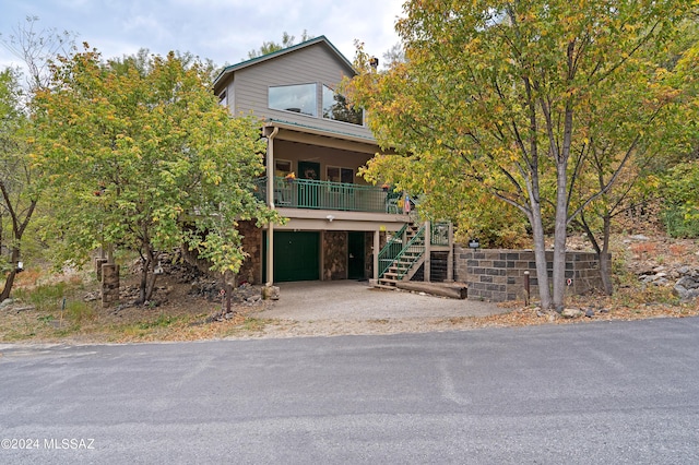 view of front of property featuring stairway, a garage, and stone siding