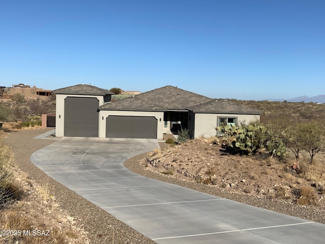 view of front of house featuring an attached garage, concrete driveway, and stucco siding