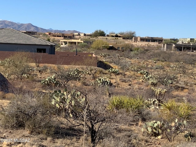 view of yard featuring a mountain view and fence