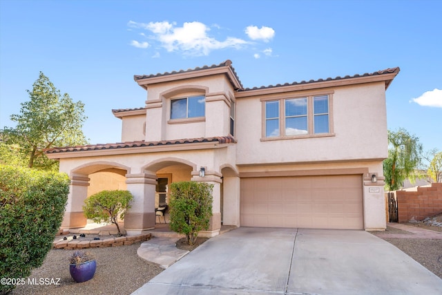 mediterranean / spanish home with a garage, fence, concrete driveway, and stucco siding