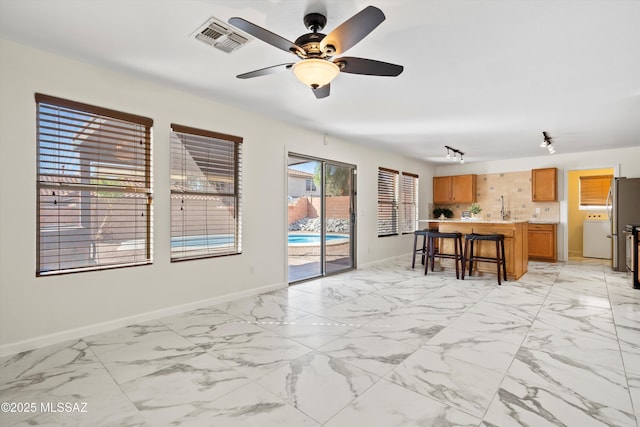 living area featuring marble finish floor, baseboards, visible vents, and a ceiling fan