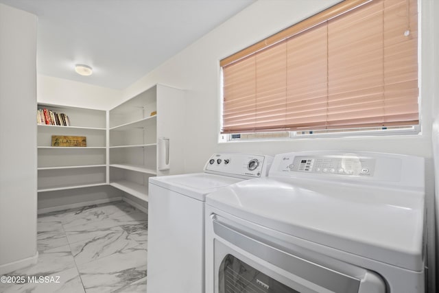 laundry area featuring washing machine and dryer, marble finish floor, and laundry area