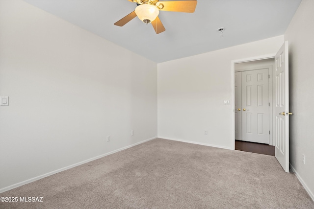 carpeted empty room with ceiling fan and baseboards