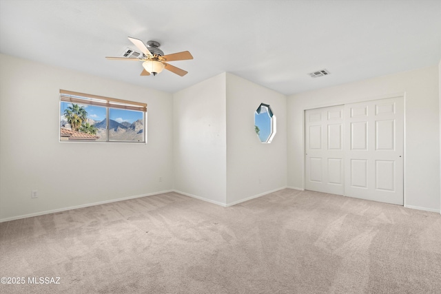 interior space featuring carpet floors, a closet, visible vents, a ceiling fan, and baseboards