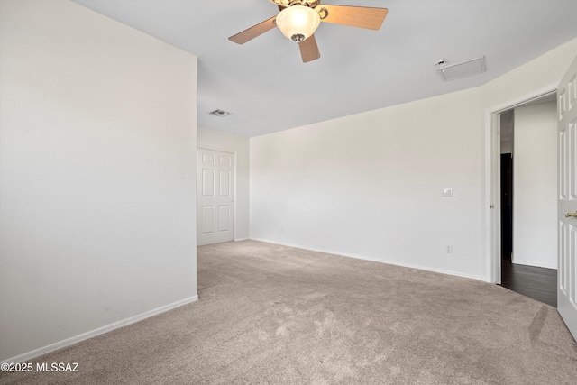 spare room with a ceiling fan, carpet, visible vents, and baseboards