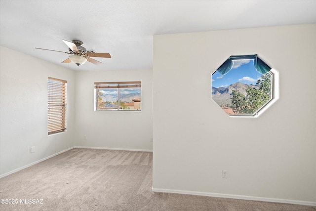 unfurnished room with a ceiling fan, baseboards, and carpet flooring