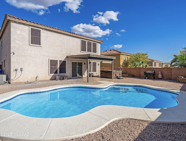 view of swimming pool featuring a patio, a fenced backyard, a jacuzzi, central AC, and a fenced in pool