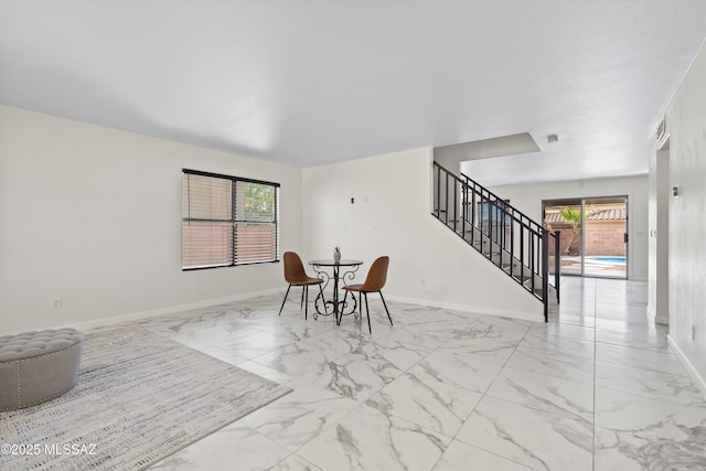 dining area with marble finish floor, stairway, and baseboards