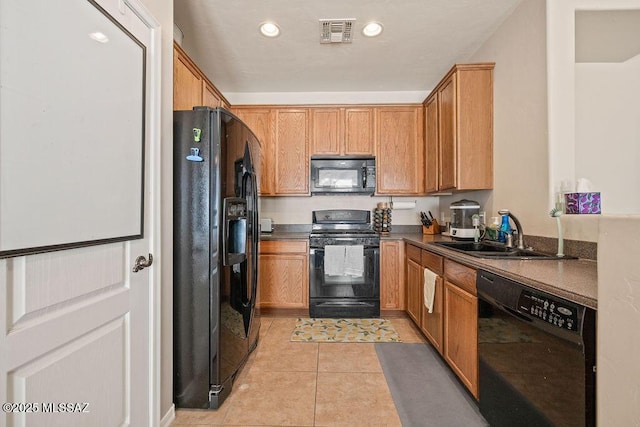 kitchen featuring visible vents, dark countertops, a sink, light tile patterned floors, and black appliances