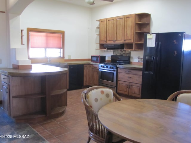 kitchen with brown cabinetry, open shelves, a sink, black appliances, and under cabinet range hood