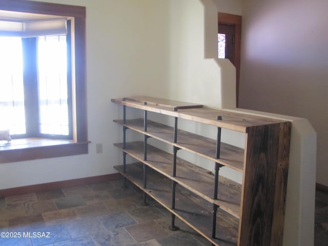 staircase featuring stone finish flooring and baseboards