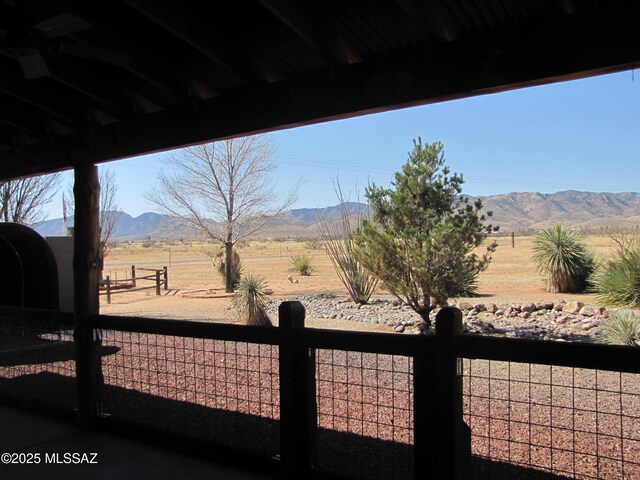 view of yard with fence, a rural view, and a mountain view