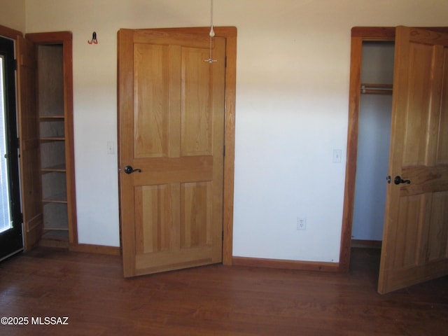 unfurnished bedroom featuring baseboards and wood finished floors