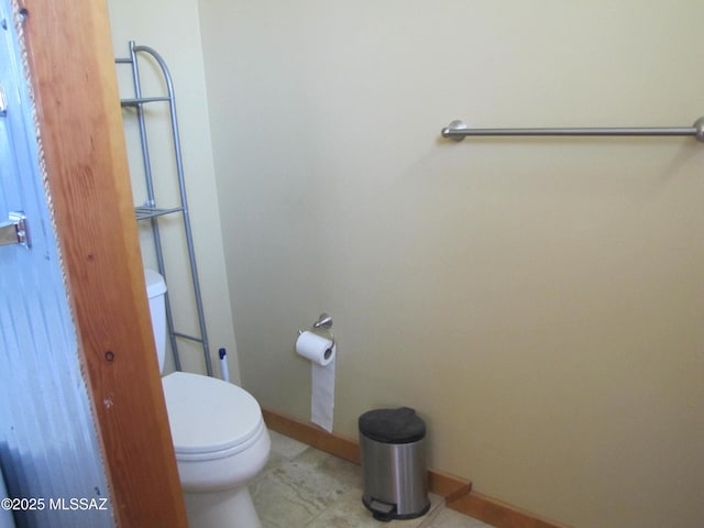 bathroom featuring toilet and baseboards
