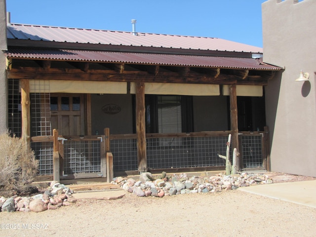 exterior space with stucco siding and metal roof