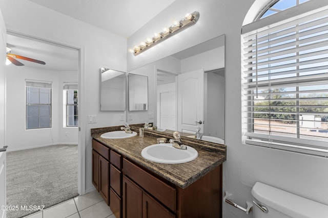 bathroom featuring a sink, toilet, ceiling fan, and tile patterned floors