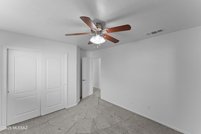 unfurnished bedroom with visible vents, a closet, carpet floors, baseboards, and ceiling fan