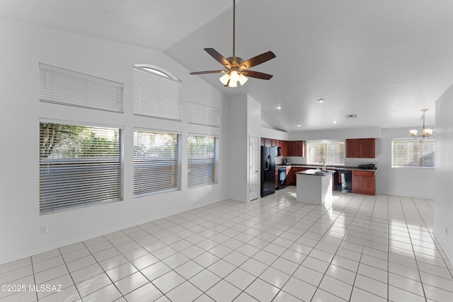 kitchen with black appliances, dark countertops, open floor plan, light tile patterned floors, and dark brown cabinets