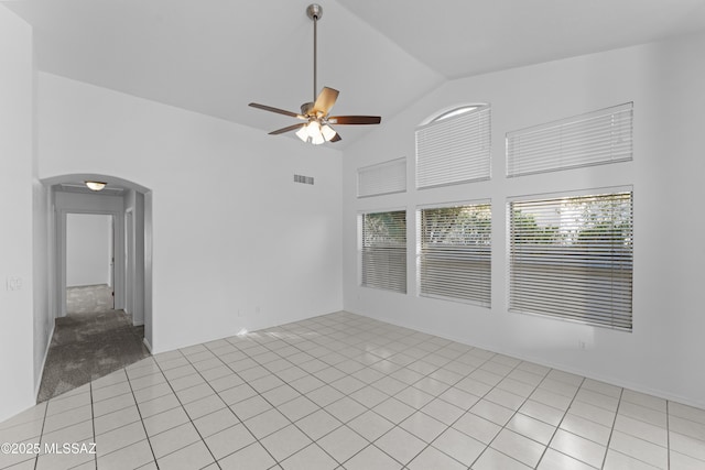 unfurnished room featuring visible vents, ceiling fan, light tile patterned floors, arched walkways, and high vaulted ceiling