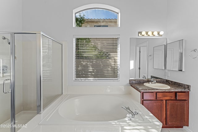 full bathroom featuring a bath, a shower stall, and vanity