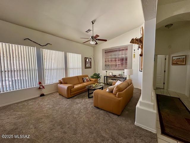 living area featuring visible vents, lofted ceiling, carpet, and a ceiling fan