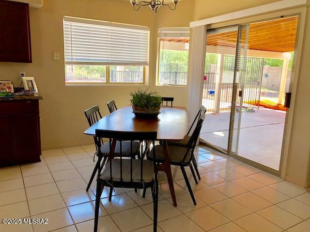 dining space with light tile patterned floors and a chandelier