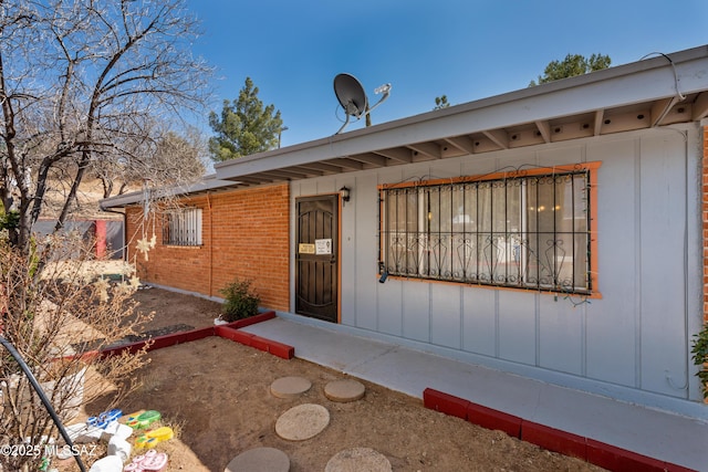 entrance to property with brick siding and board and batten siding