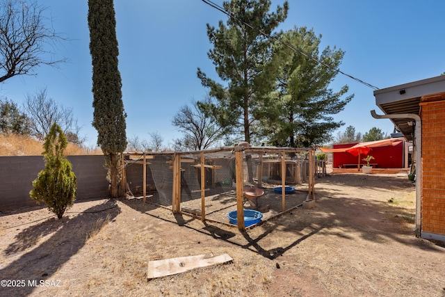 view of yard featuring an outbuilding, a fenced backyard, and exterior structure