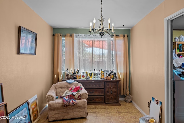 sitting room with an inviting chandelier and baseboards