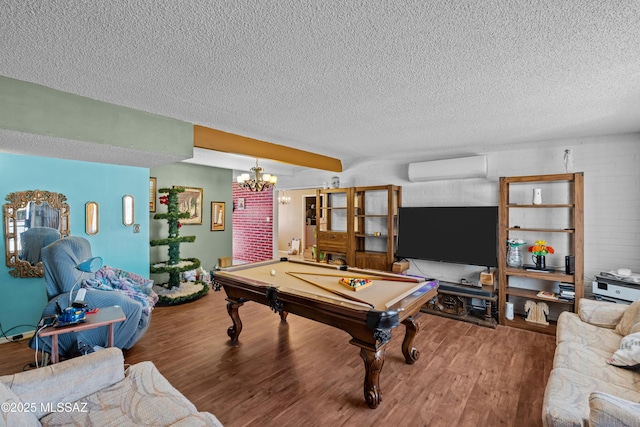 recreation room featuring a wall unit AC, billiards, wood finished floors, and a textured ceiling