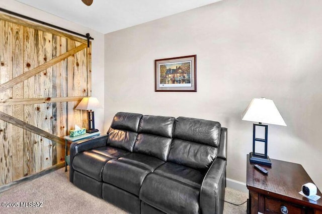 living room with a barn door, carpet flooring, and baseboards