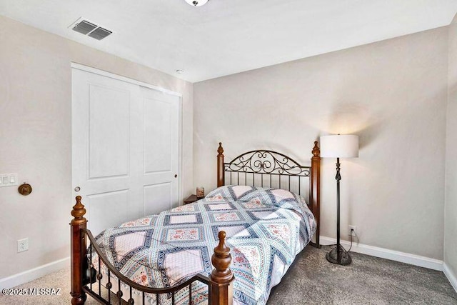 carpeted bedroom with visible vents, baseboards, and a closet