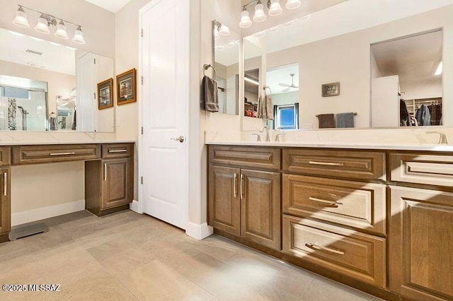 bathroom featuring vanity, a walk in closet, and baseboards