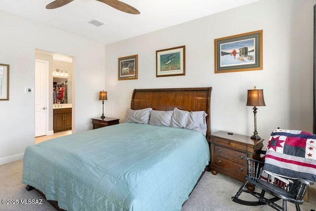 bedroom with visible vents, baseboards, ceiling fan, ensuite bathroom, and light colored carpet