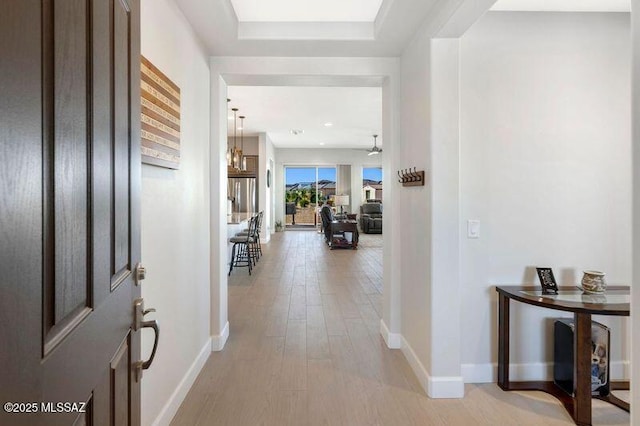 foyer featuring baseboards and light wood finished floors