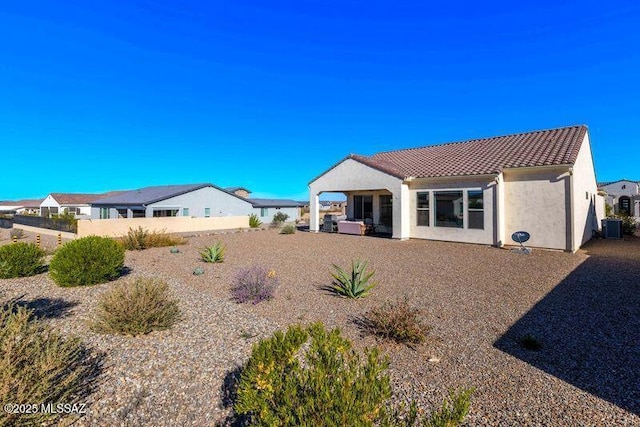 back of property featuring central air condition unit, stucco siding, a tile roof, and fence