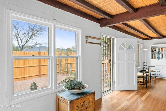 interior space with wood finished floors, wood ceiling, and beam ceiling