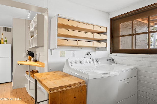 laundry area with visible vents, washing machine and dryer, laundry area, and light wood finished floors