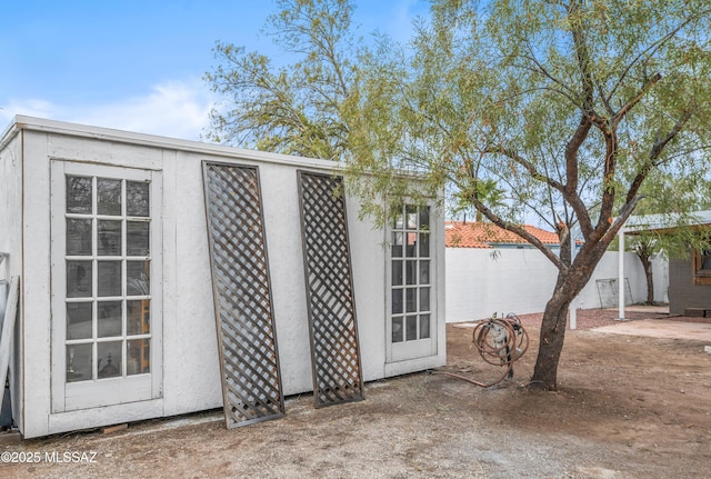 view of outbuilding featuring an outdoor structure and fence