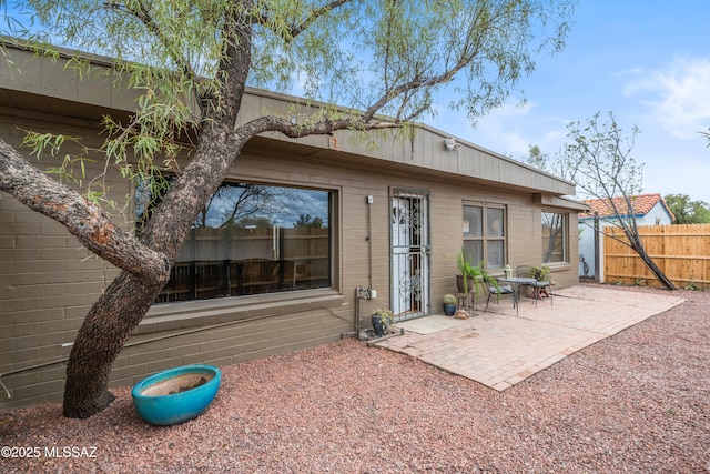 rear view of house featuring a patio and fence