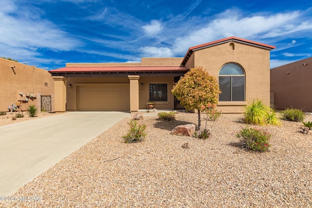 view of front of property with concrete driveway, an attached garage, and stucco siding