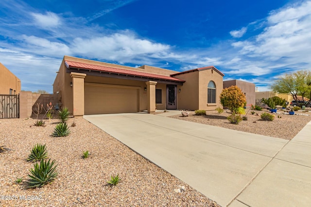 view of front facade with stucco siding, a garage, driveway, and fence