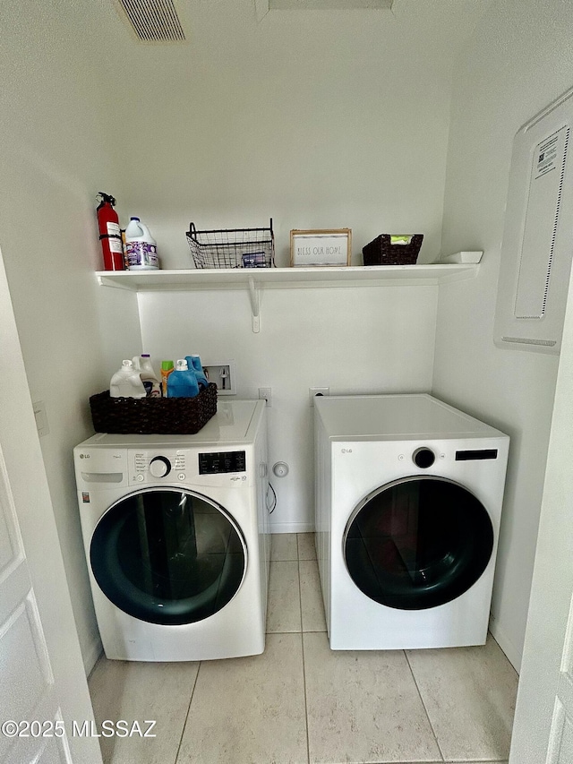 laundry area featuring washer and dryer, visible vents, baseboards, and tile patterned flooring