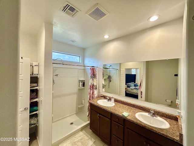 ensuite bathroom featuring a stall shower, visible vents, and a sink