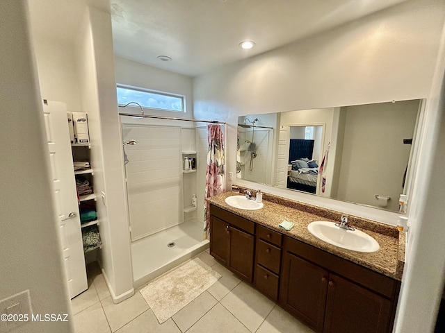 bathroom featuring tile patterned flooring, a stall shower, ensuite bath, and a sink