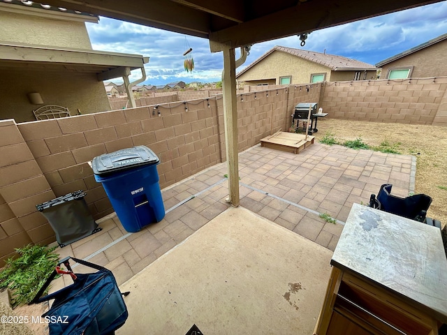 view of patio with a grill and fence