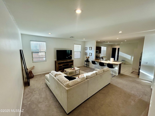 living area featuring plenty of natural light, recessed lighting, and light carpet