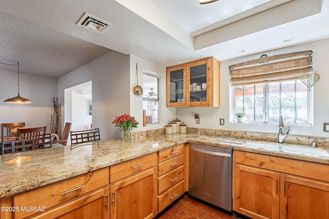 kitchen featuring visible vents, glass insert cabinets, dark wood-type flooring, stainless steel dishwasher, and a sink